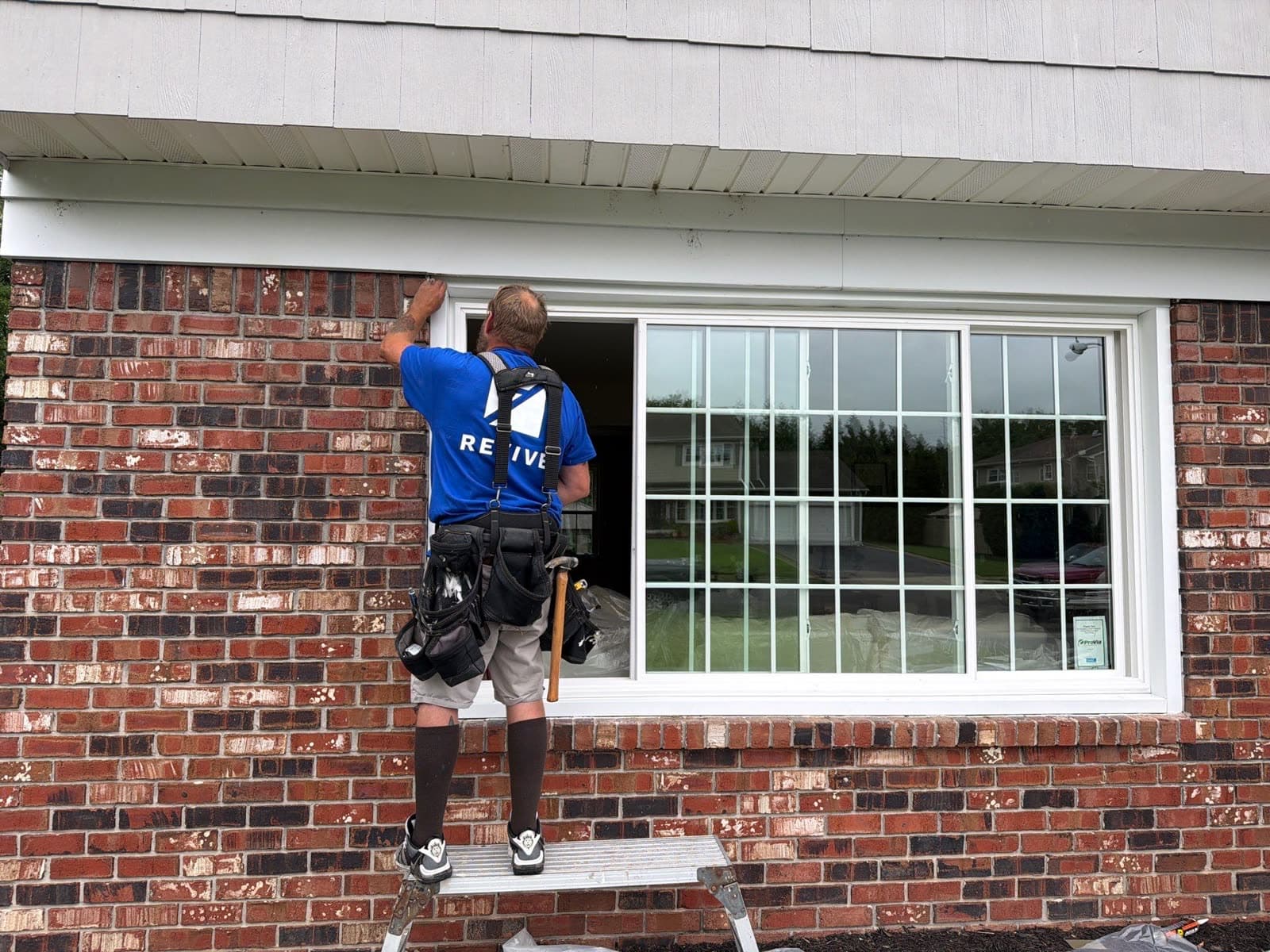 Revive installer fitting a new multi-pane ProVia window into a brick exterior in New Jersey